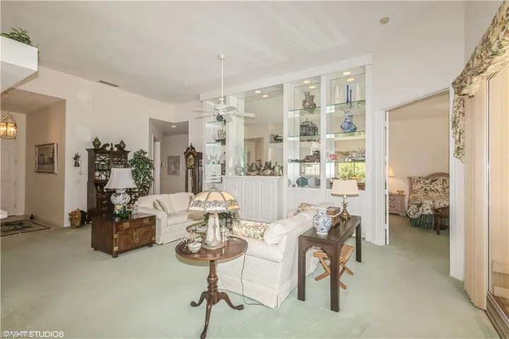 Carpeted living room featuring ceiling fan