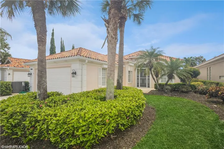 Mediterranean / spanish house with a garage, a front yard, and central AC unit
