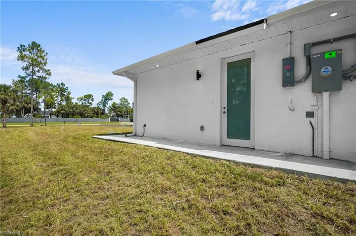 Entrance to property featuring a lawn and stucco siding