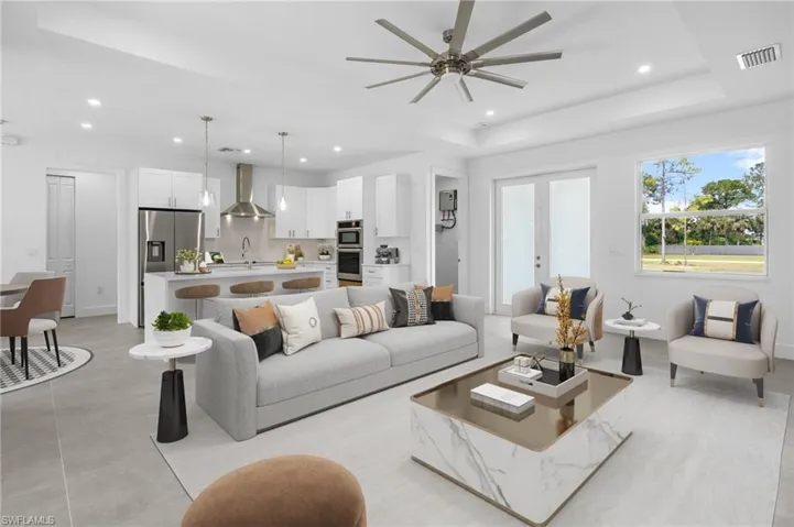 Virtually Staged Living area with a tray ceiling, french doors, recessed lighting, and ceiling fan