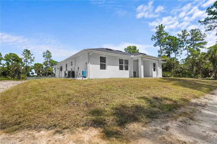 View of front of home with stucco siding and a front yard