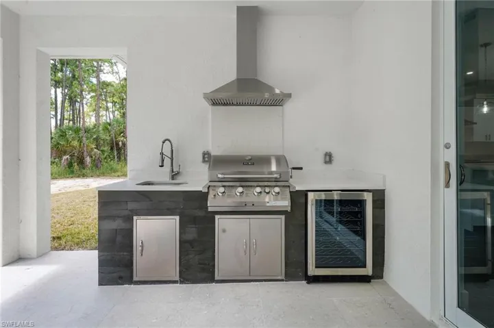 View of patio featuring beverage cooler and an outdoor kitchen