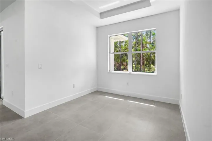 Empty room featuring baseboards and light tile patterned flooring