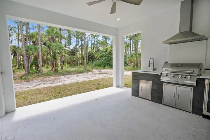 View of patio / terrace with area for grilling, ceiling fan, and beverage cooler