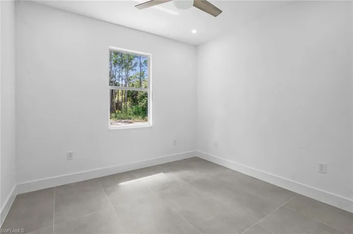 Empty room with light tile patterned floors, ceiling fan, and recessed lighting