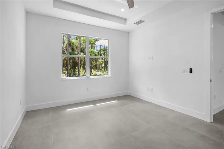 Unfurnished room with a tray ceiling, light tile patterned floors, a ceiling fan, and recessed lighting