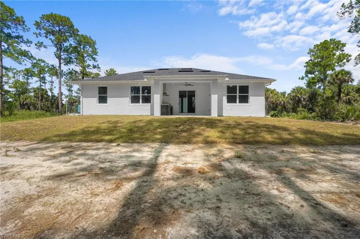 Rear view of house with a patio area, a yard, ceiling fan, and stucco siding