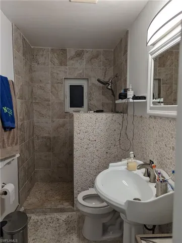 Bathroom with a shower stall and tile walls
