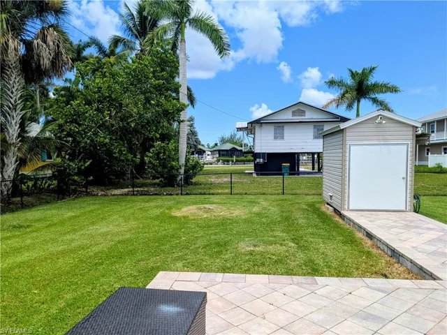 Fenced backyard featuring a shed