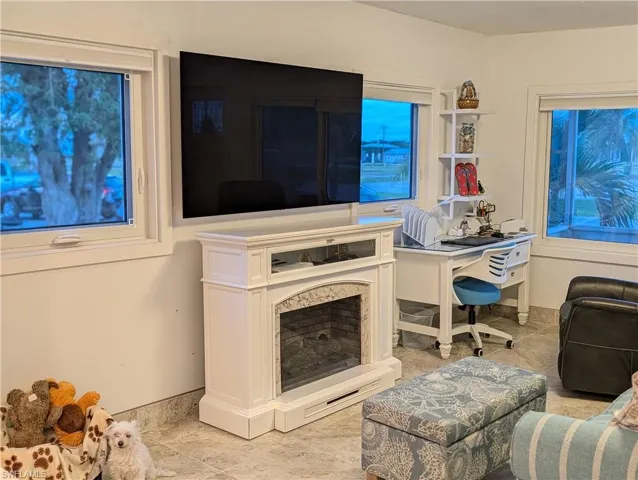 Living room featuring light tile patterned floors and an office area