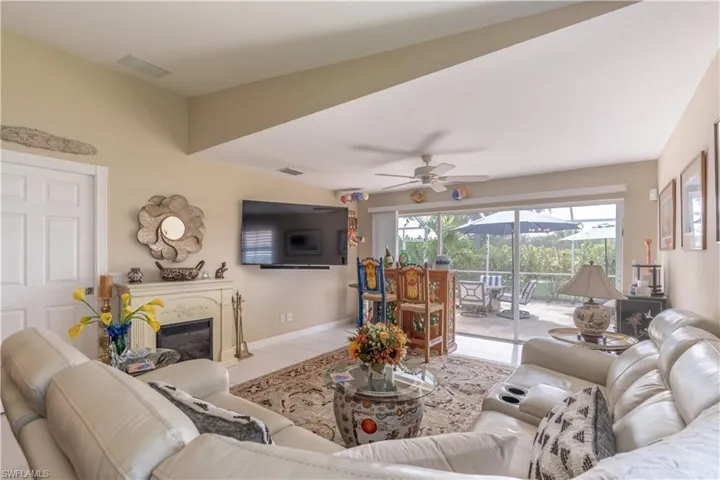Living room with ceiling fan and light tile floors