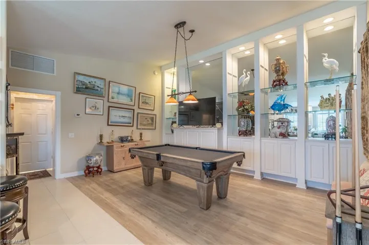 Playroom with vaulted ceiling, pool table, and light tile flooring