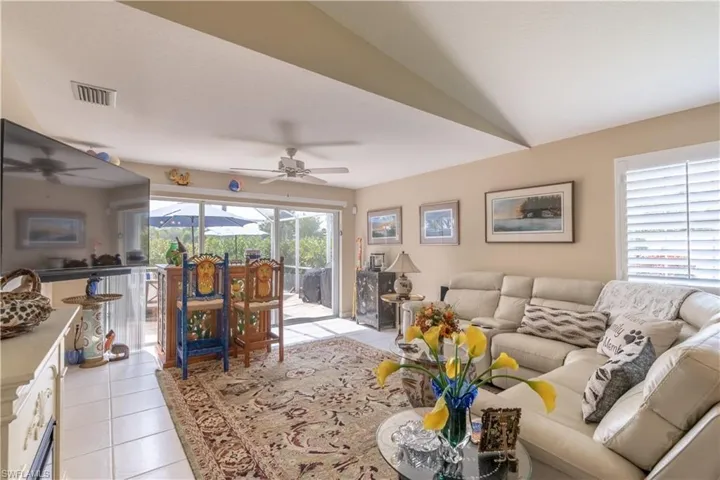 Tiled living room featuring vaulted ceiling and ceiling fan