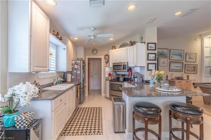 Kitchen featuring stone counters, white cabinets, and appliances with stainless steel finishes