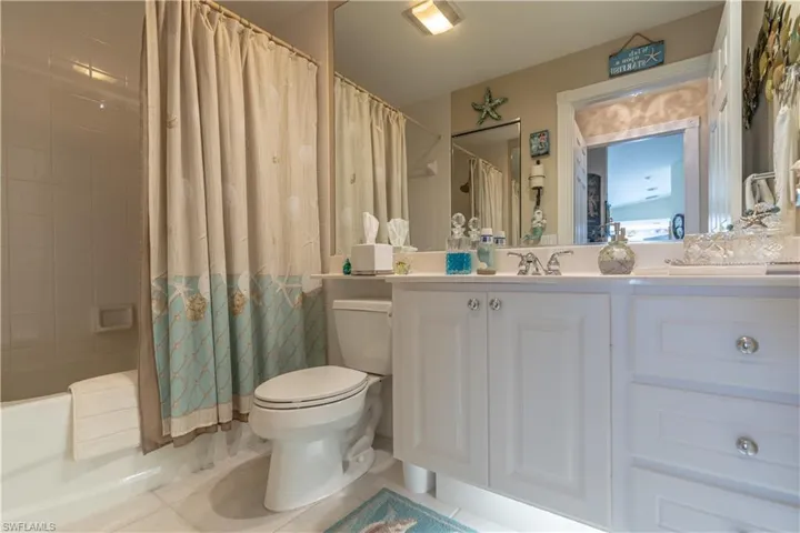 Full bathroom with vanity, toilet, tile floors, and shower / tub combo with curtain