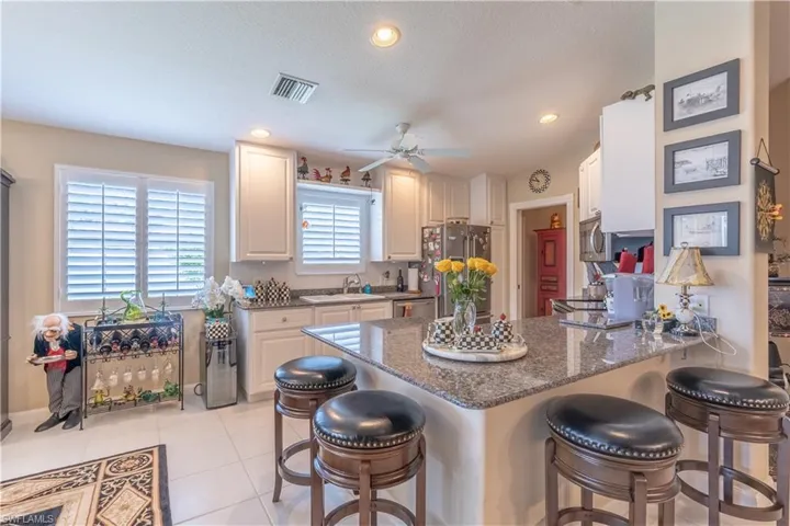 Kitchen with appliances with stainless steel finishes, a breakfast bar area, kitchen peninsula, sink, and light tile flooring