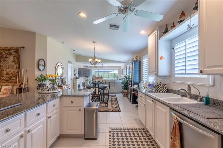Kitchen with a wealth of natural light, white cabinets, and light tile flooring