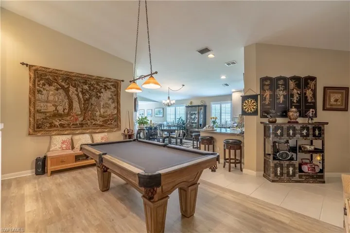 Playroom with a notable chandelier, light tile flooring, vaulted ceiling, and pool table