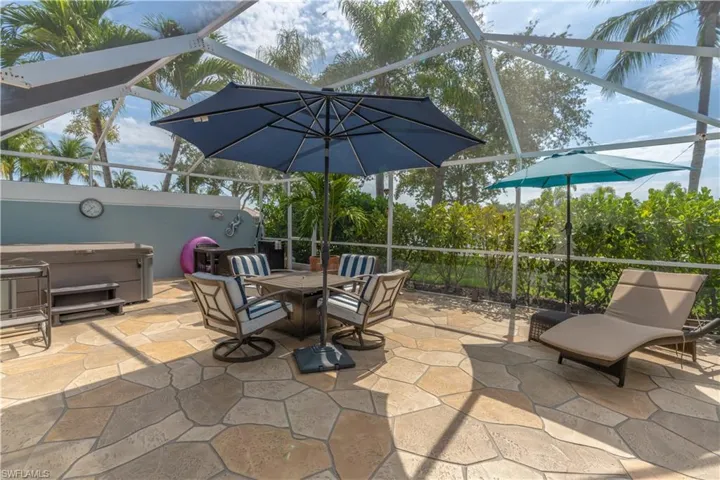 View of patio / terrace with a hot tub and glass enclosure