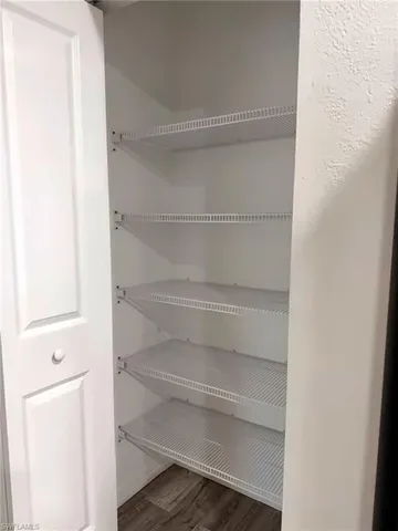 Built-in wire shelving, white paneled door, wood-finish flooring