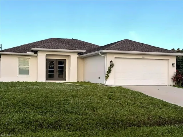 Stucco exterior with a hip roof, double entry doors, two-car garage, and a concrete driveway