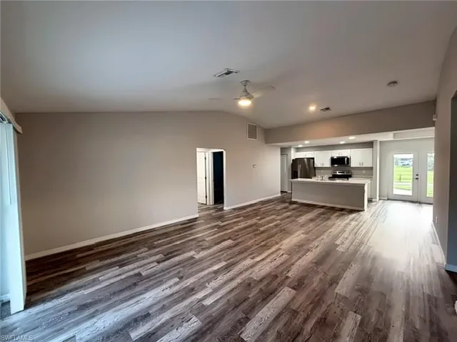 Vaulted ceilings with recessed lighting, wood-finish flooring, and a ceiling fan