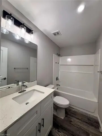Modern vanity with white cabinetry, light-colored countertop, and integrated sink