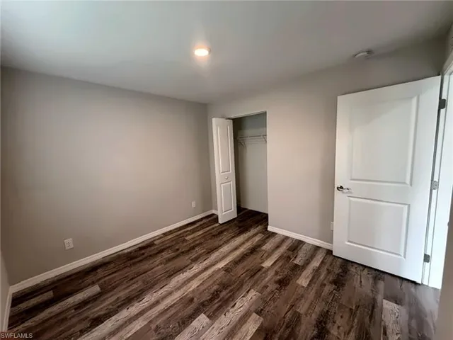 Wood-finish flooring throughout, light-toned wall paint, recessed lighting, and a bi-fold closet door