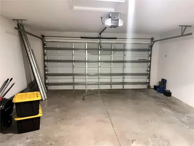 Attached garage with an overhead door, smooth concrete flooring, and an automatic garage door opener