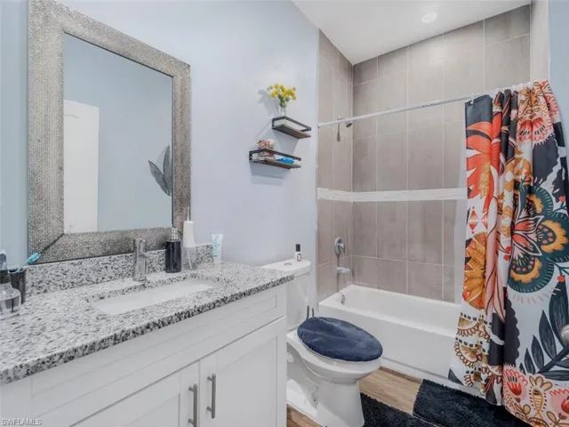 Bathroom with shower / tub combo with curtain and vanity