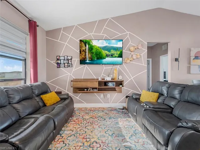 Living room with an accent wall and lofted ceiling