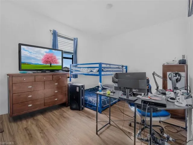 Bedroom with a desk and wood finished floors