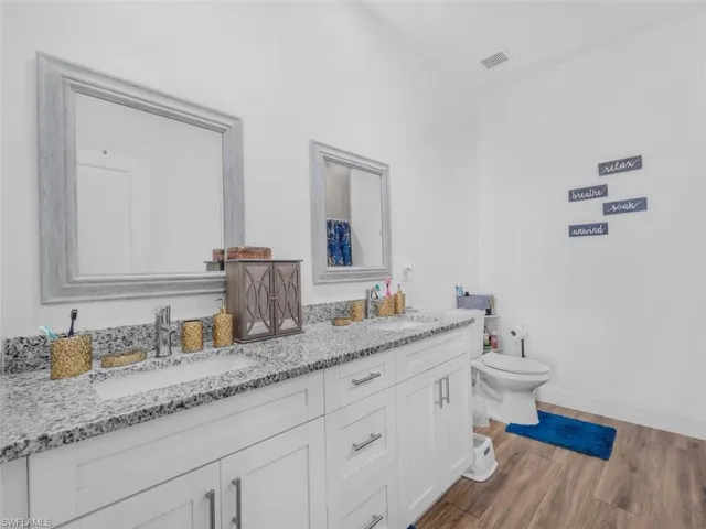 Bathroom featuring double vanity and light wood-style flooring
