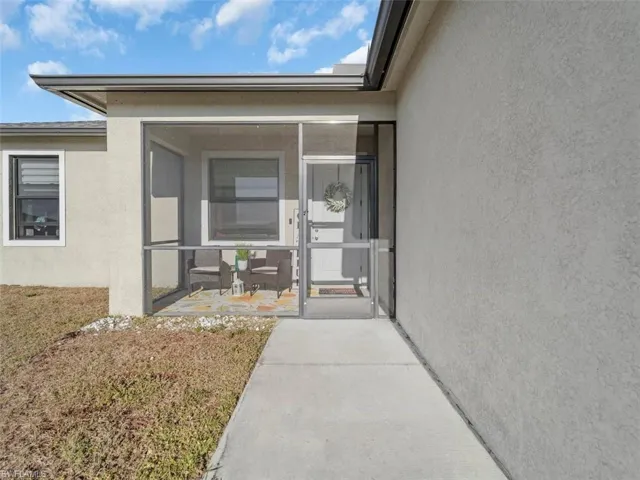 Doorway to property with stucco siding and a sunroom