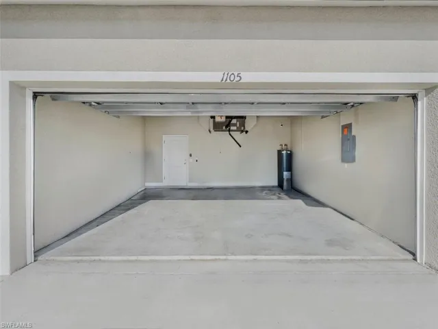 Garage featuring electric panel and water heater