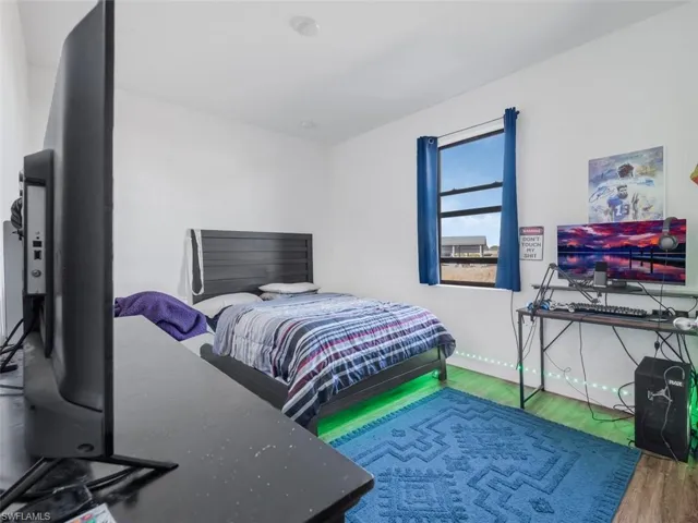 Bedroom with wood finished floors and baseboards