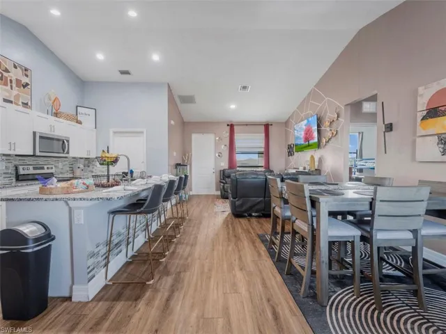 Dining room with light wood-style floors and recessed lighting