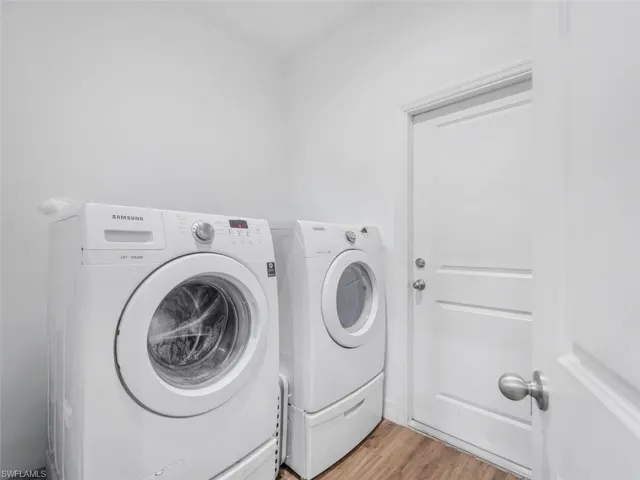 Laundry room with independent washer and dryer and light wood-style floors