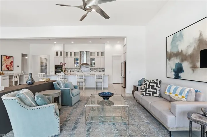 Living room with ceiling fan, light tile patterned floors, and recessed lighting