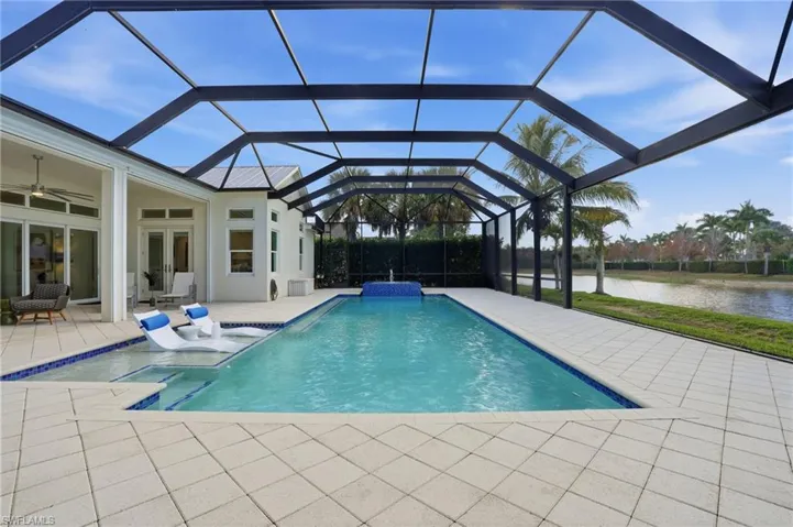 Swimming pool with a lanai, a sunroom, a patio area, french doors, and a water view
