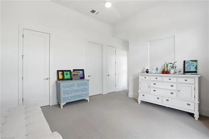Bedroom with light colored carpet and baseboards
