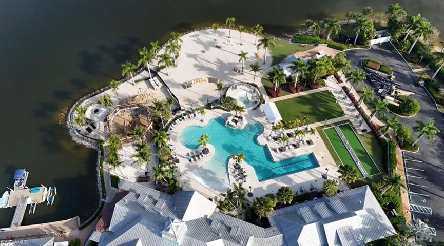 Drone / aerial view of a pool area and a nearby body of water