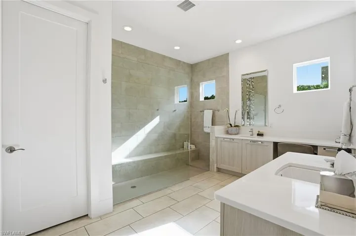 Full bathroom featuring vanity, walk in shower, recessed lighting, and light tile patterned floors