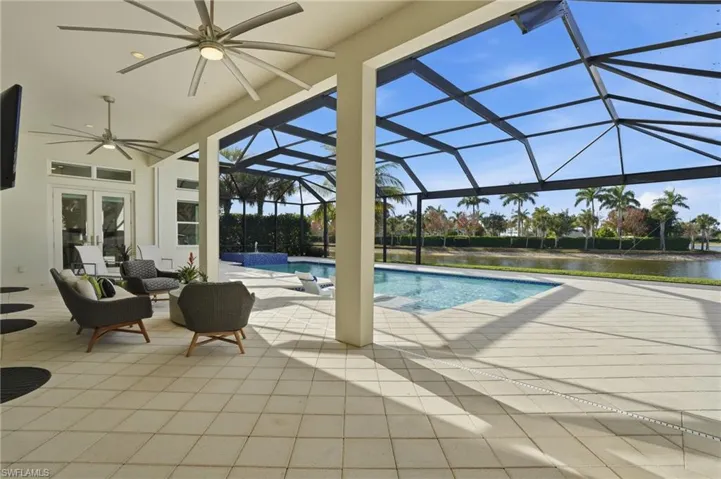 View of swimming pool featuring a sunroom, a patio, a lanai, french doors, and a pool with connected hot tub
