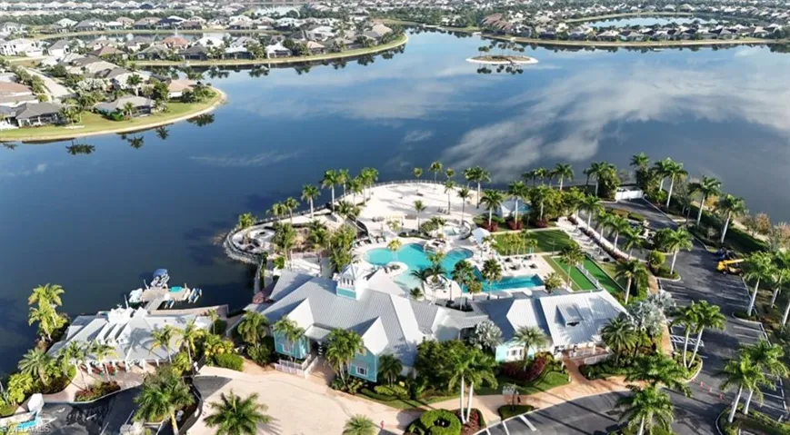 Aerial view of property and surrounding area with a large body of water and nearby suburban area