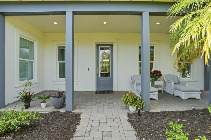 Entrance to property with covered porch and stucco siding