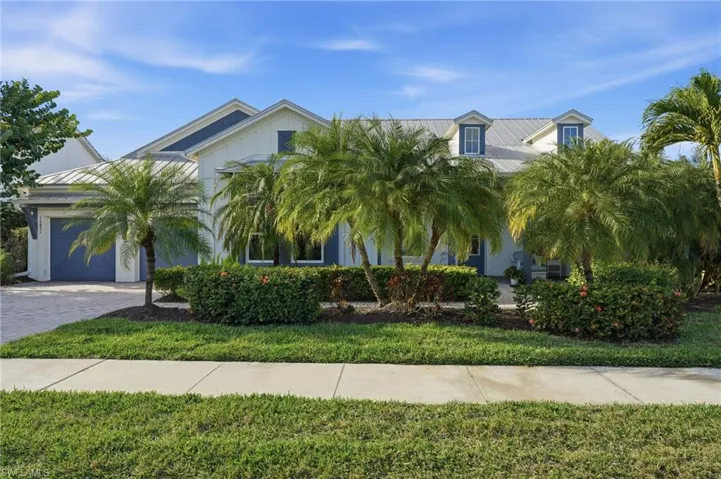 View of front of house featuring a metal roof, an attached garage, decorative driveway, and a front yard