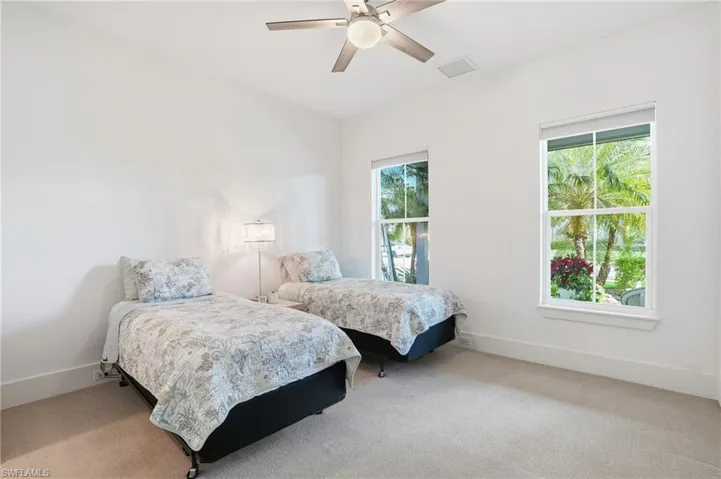 Carpeted bedroom with baseboards and a ceiling fan
