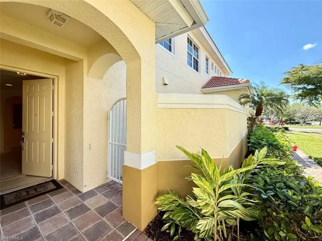 Doorway to property with a tiled roof and stucco siding