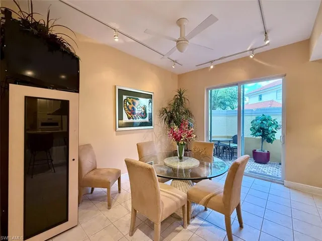 Dining space featuring light tile patterned flooring, ceiling fan, and track lighting